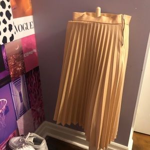 Nude pleated below the knee skirt